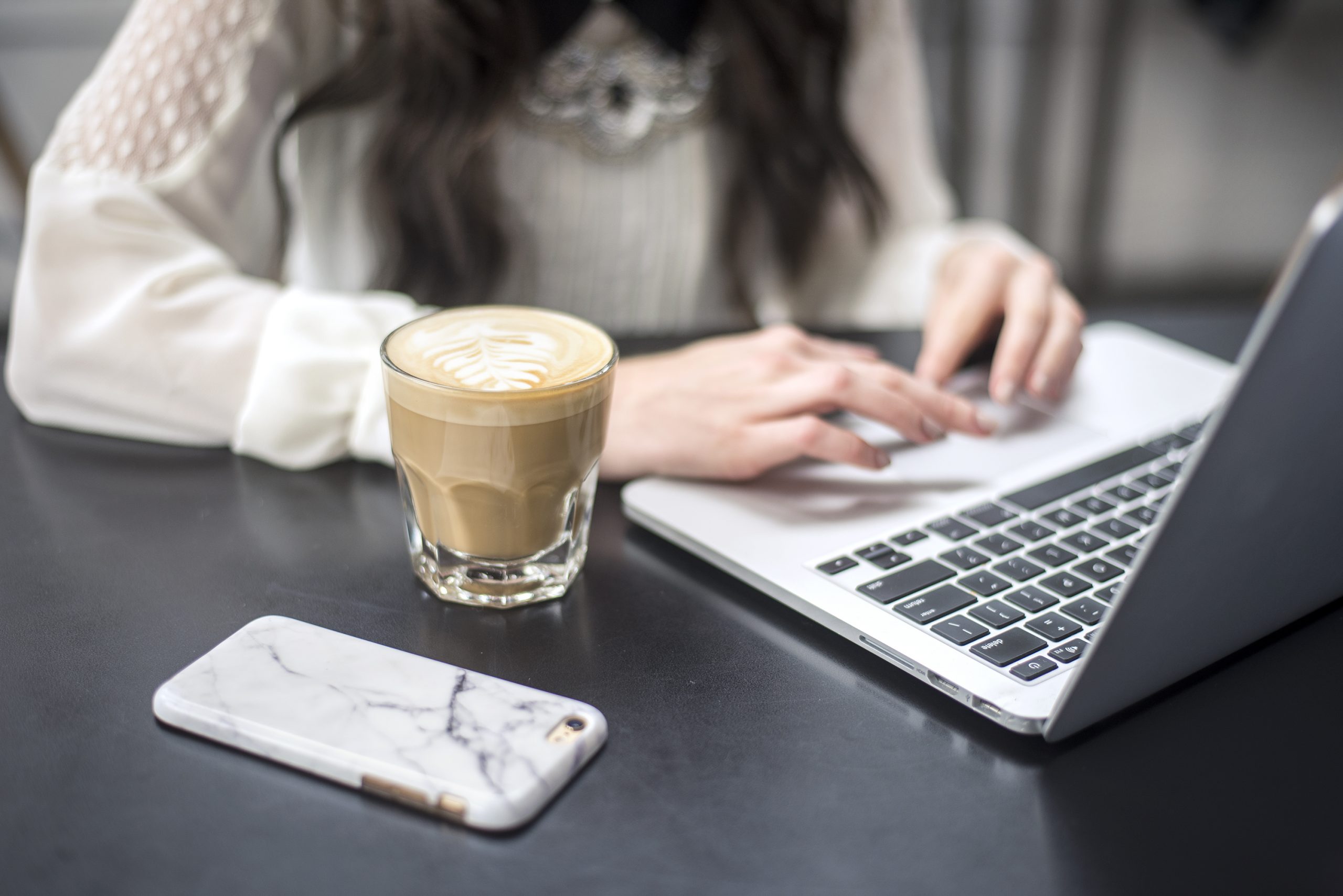 Person holding silver iphone 6 near macbook pro