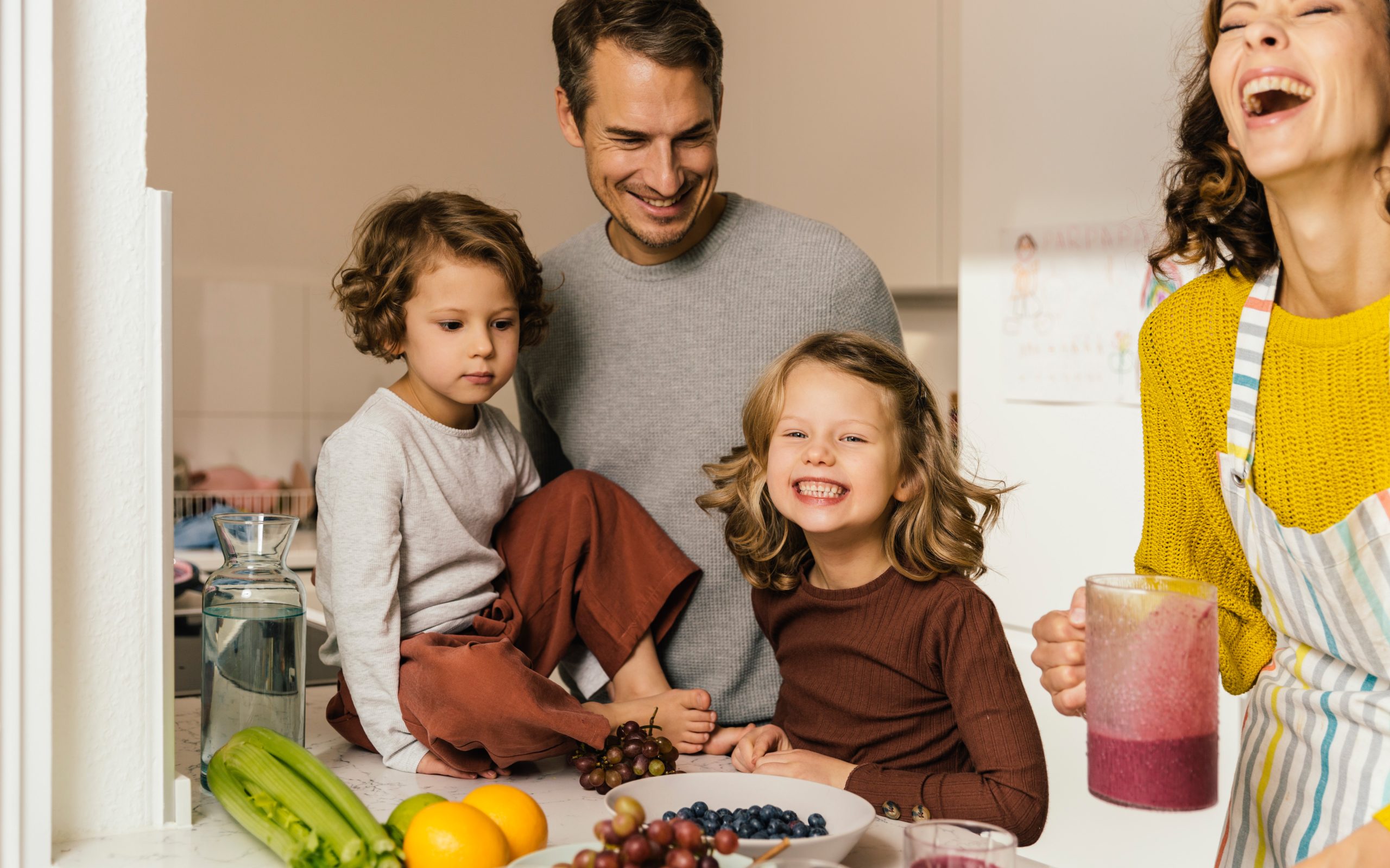 Happy family making a smoothie in kitchen